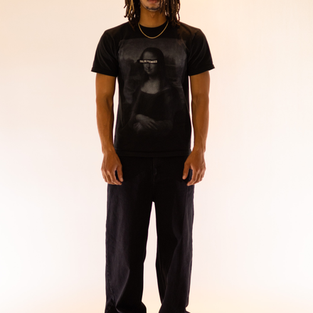 model wearing Black fitted t-shirt made from 100% cotton, featuring a customized Mona Lisa graphic on the front and the False Promises brand slogan on the back.