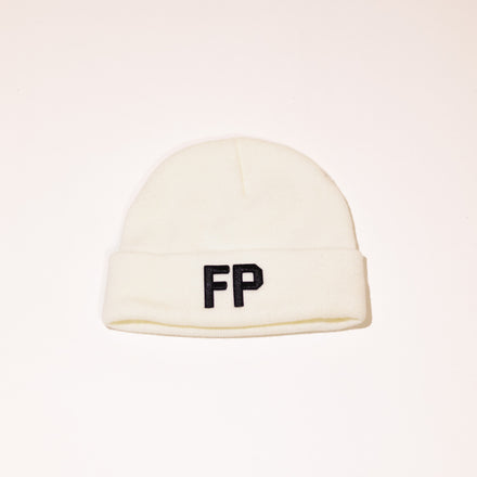White ribbed knit beanie with folded cuff, featuring a black embroidered False Promises logo on the front.